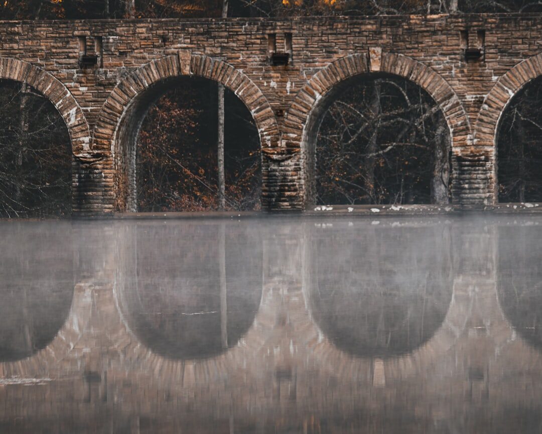 Old stone bridge over a canal in fog