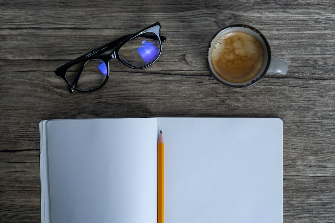 Open notebook, pen and cup of coffee on a desk