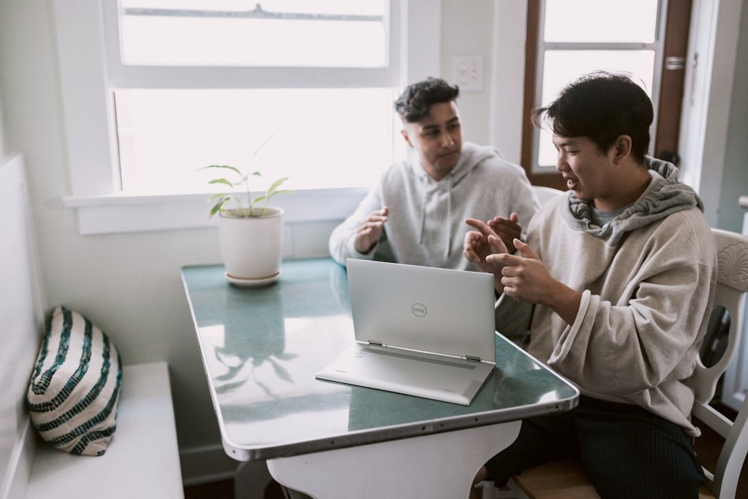 Small editorial team discussing around a table with laptops